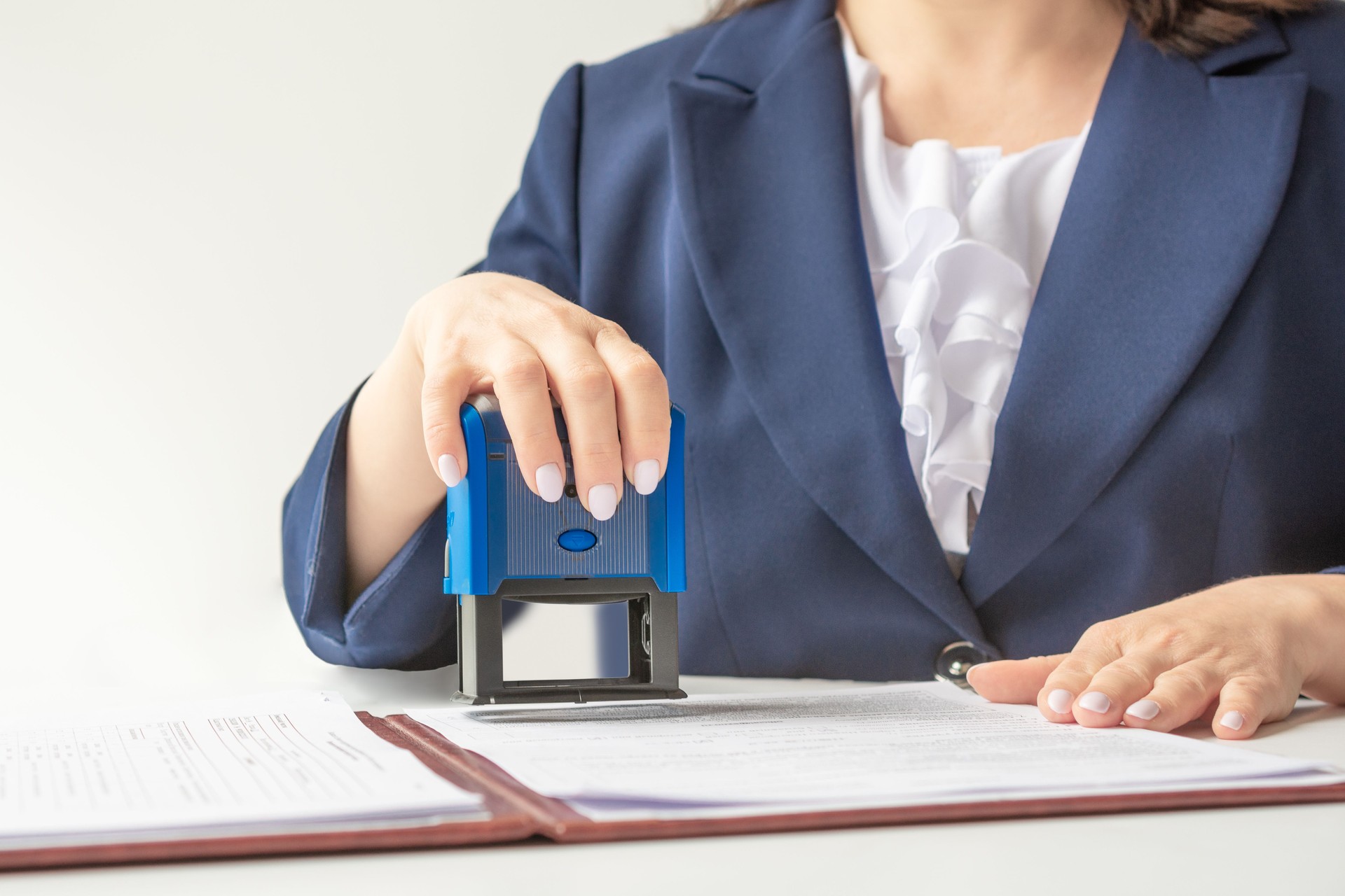 official notary Putting Stamp On Documents. in a blue jacket