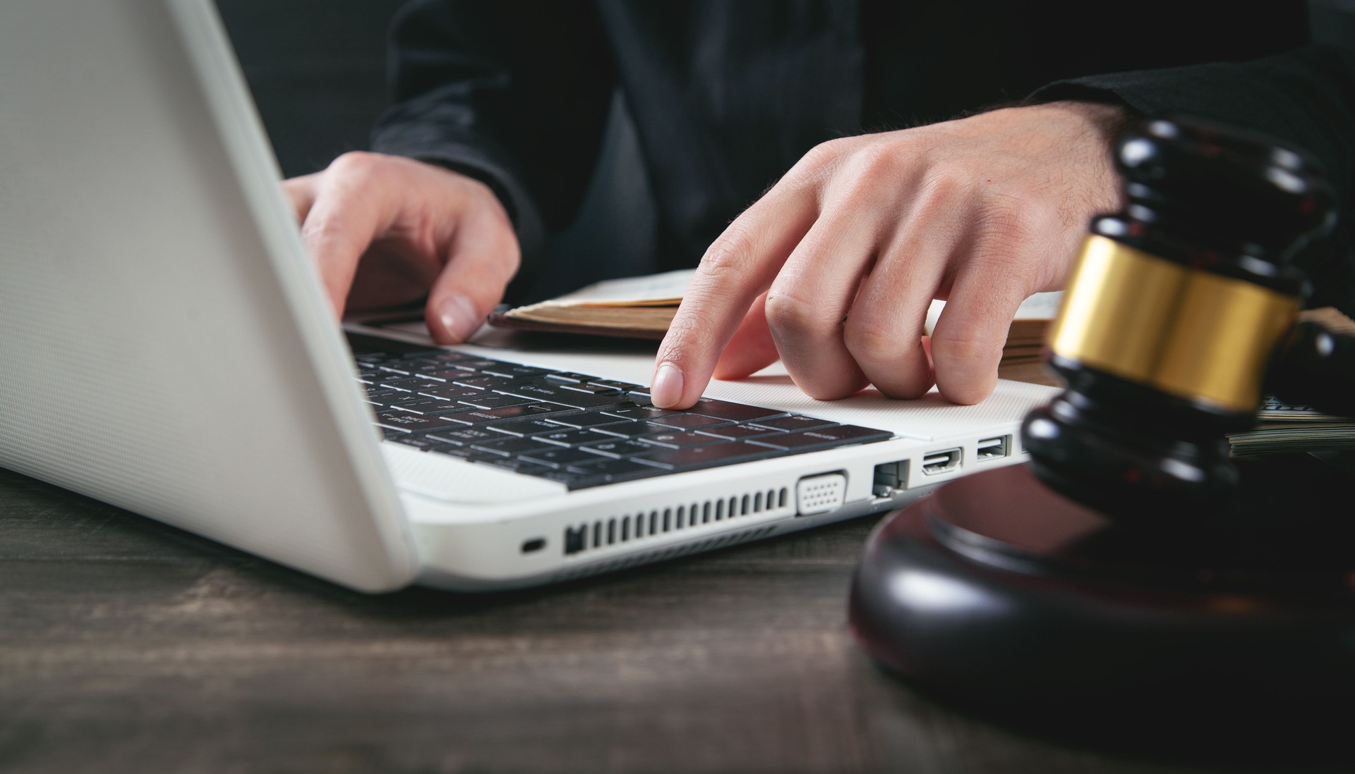 Male judge typing in laptop keyboard. Justice and law